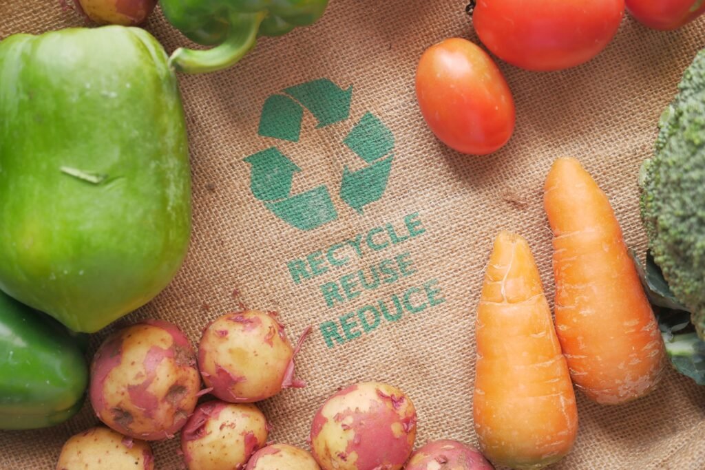 Fresh vegetables on a burlap bag with recycle symbol, promoting eco-friendly choices.