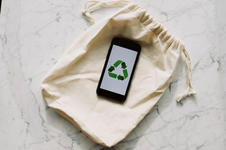 Smartphone displaying recycling icon on a drawstring pouch. Eco-conscious and sustainable theme.